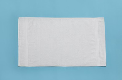 White beach towel on light blue background, top view Photo of White beach towel on light blue background, top view