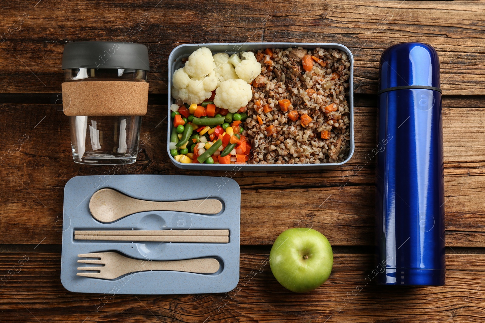 Flat lay composition with thermos and lunch box on wooden background Photo of Flat lay composition with thermos and lunch box on wooden background