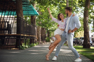 Lovely young couple dancing together outdoors on sunny day Photo of Lovely young couple dancing together outdoors on sunny day