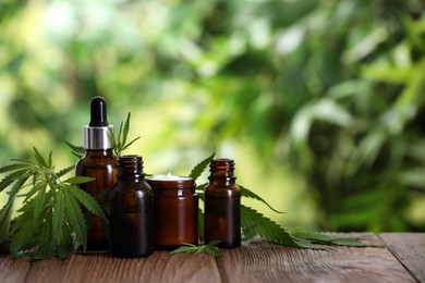 Cream, hemp leaves, bottles of CBD oil and THC tincture on wooden table. Space for text Photo of Cream, hemp leaves, bottles of CBD oil and THC tincture on wooden table. Space for text
