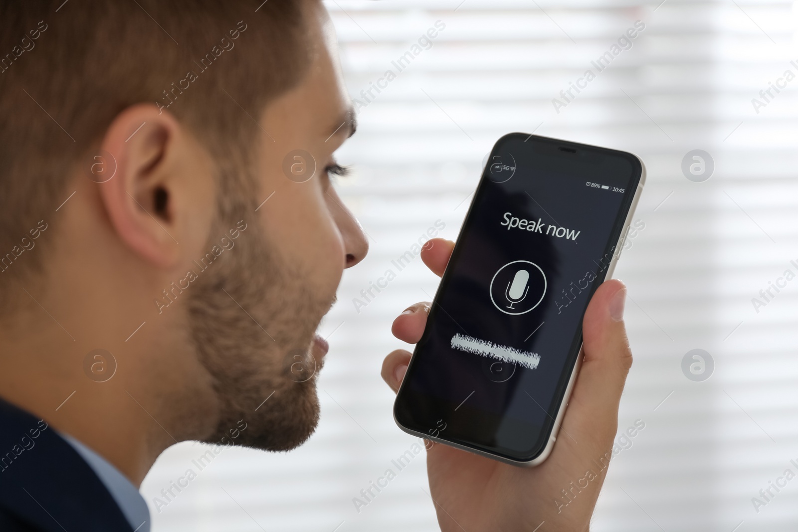 Young man using voice search on smartphone indoors, closeup Photo of Young man using voice search on smartphone indoors, closeup