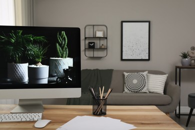 Comfortable workplace with computer on wooden desk in modern office. Interior design Photo of Comfortable workplace with computer on wooden desk in modern office. Interior design