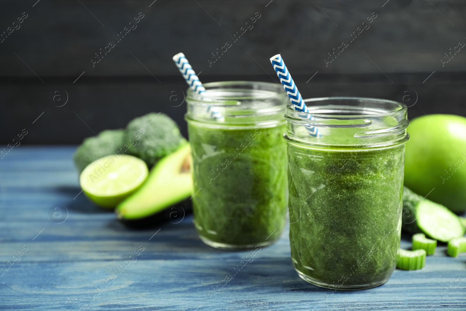 Delicious fresh green juice on blue wooden table. Space for text Photo of Delicious fresh green juice on blue wooden table. Space for text