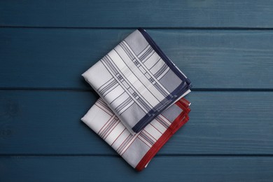 Stylish handkerchiefs on blue wooden table, flat lay Photo of Stylish handkerchiefs on blue wooden table, flat lay
