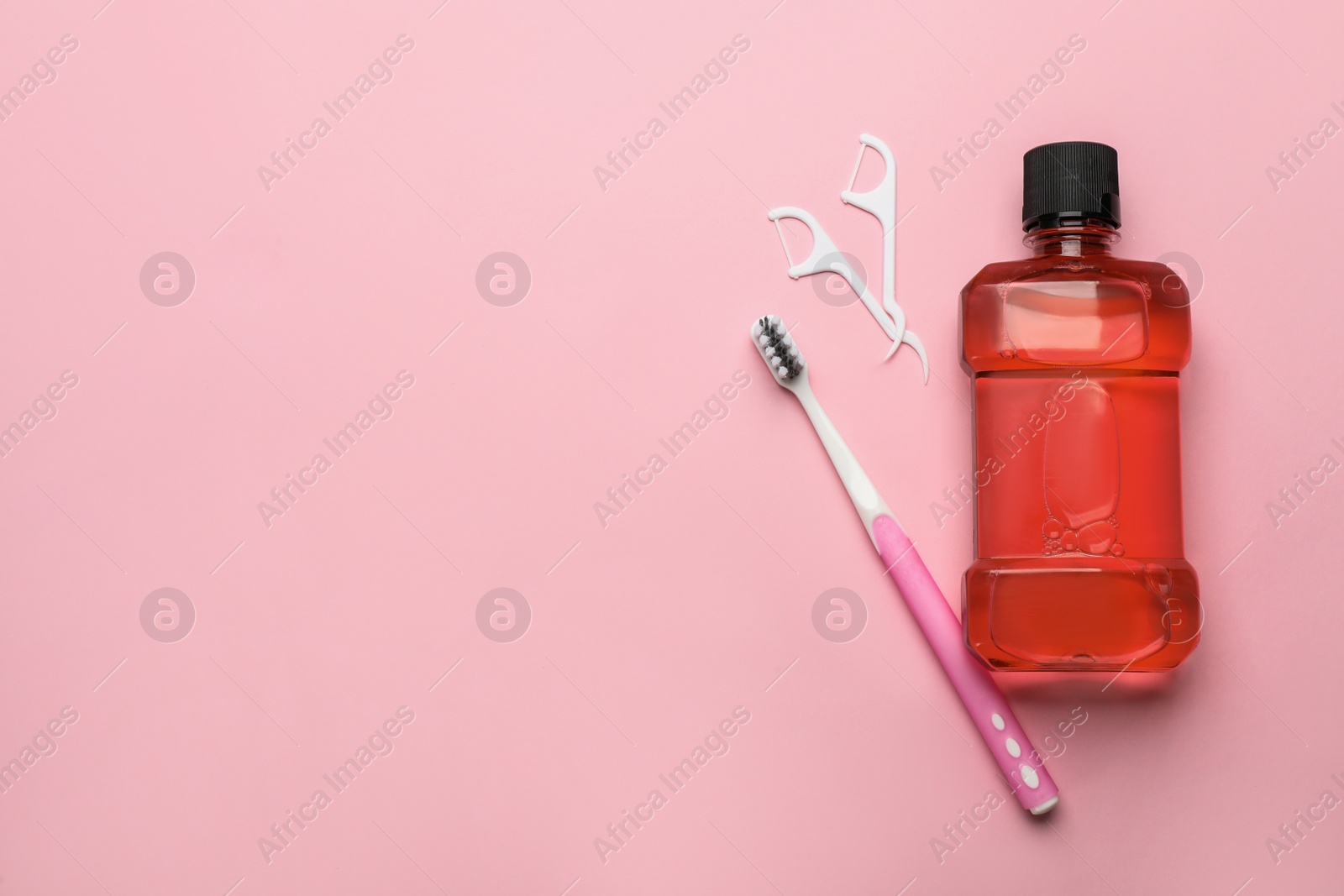 Mouthwash, toothbrush and dental floss on pink background, flat lay. Space for text Photo of Mouthwash, toothbrush and dental floss on pink background, flat lay. Space for text