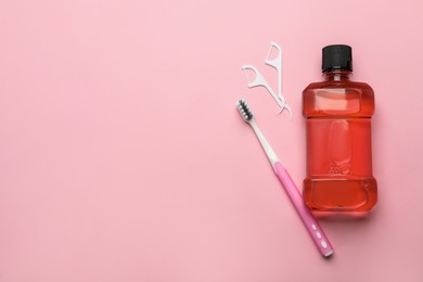 Mouthwash, toothbrush and dental floss on pink background, flat lay. Space for text Photo of Mouthwash, toothbrush and dental floss on pink background, flat lay. Space for text
