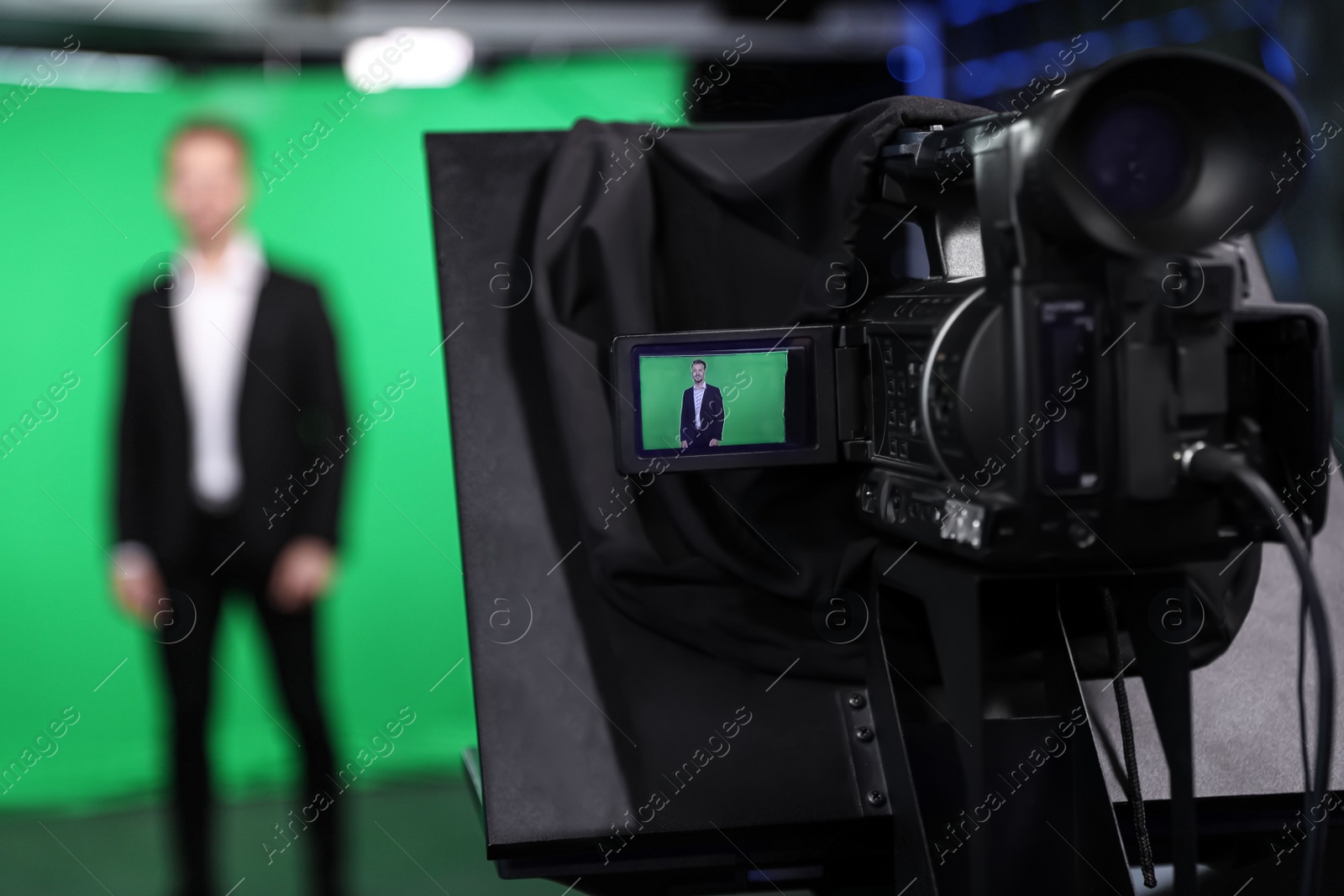 Photo of Presenter working in studio, focus on video camera screen
