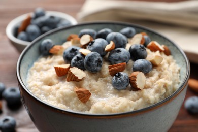 Tasty oatmeal porridge with blueberries and almond nuts on table, closeup Photo of Tasty oatmeal porridge with blueberries and almond nuts on table, closeup