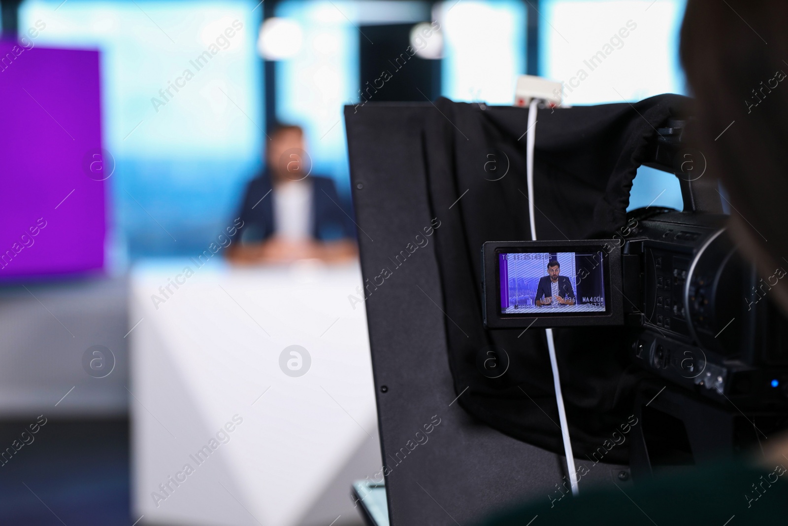 Presenter and video camera operator working in studio. News broadcasting Photo of Presenter and video camera operator working in studio. News broadcasting