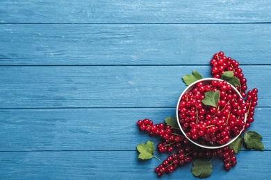 Delicious red currants and leaves on blue wooden table, flat lay. Space for text Photo of Delicious red currants and leaves on blue wooden table, flat lay. Space for text