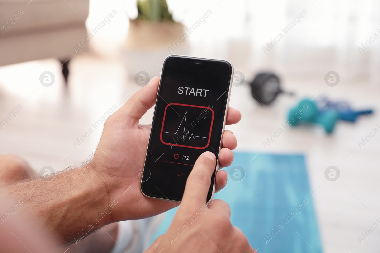 Photo of Man using fitness app on smartphone at home, closeup