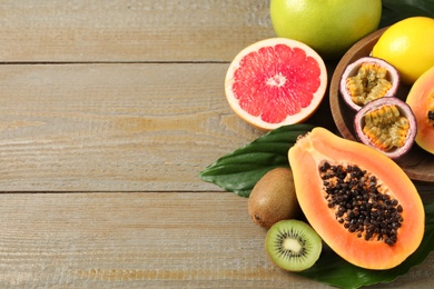 Fresh ripe papaya and other fruits on wooden table, above view. Space for text Photo of Fresh ripe papaya and other fruits on wooden table, above view. Space for text