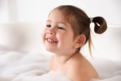 Cute little girl taking bubble bath at home Photo of Cute little girl taking bubble bath at home