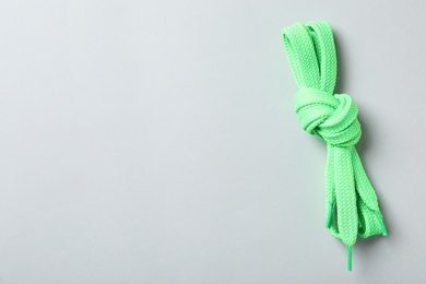 Photo of Green shoelaces on light background, top view. Space for text