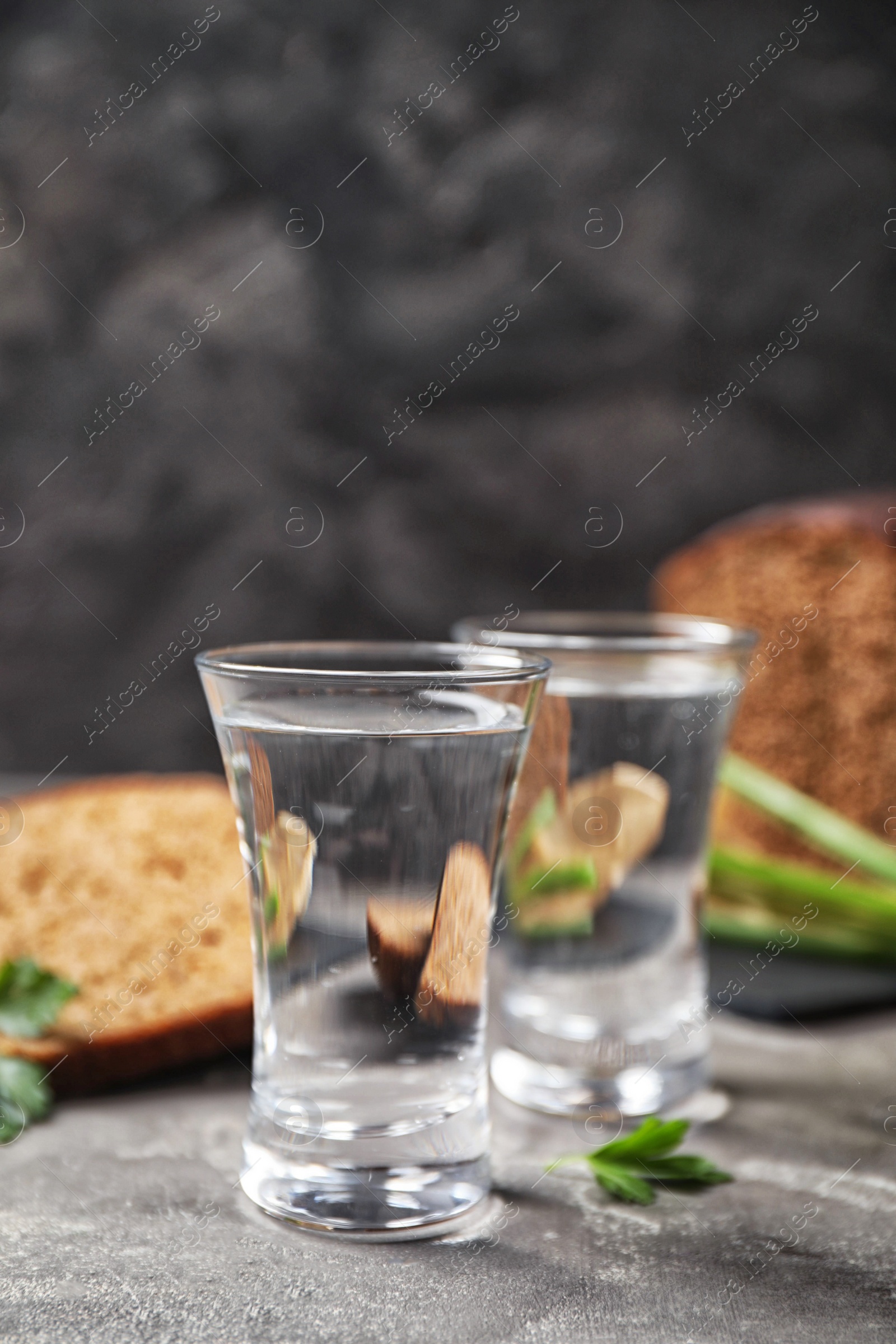 Cold Russian vodka with snacks on grey table, closeup Photo of Cold Russian vodka with snacks on grey table, closeup