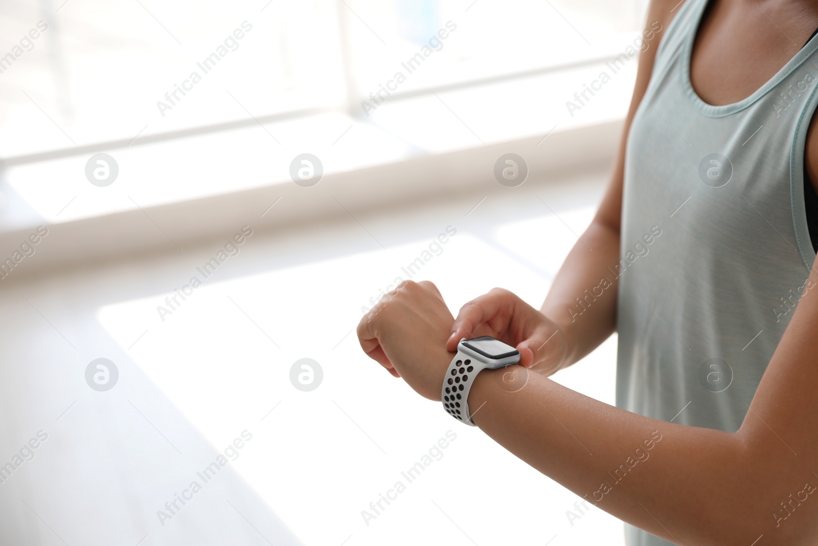 Woman checking fitness tracker in gym, closeup. Space for text Photo of Woman checking fitness tracker in gym, closeup. Space for text