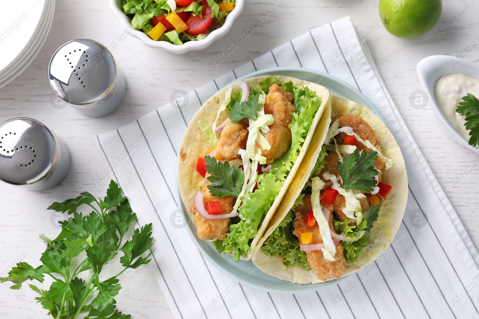 Yummy fish tacos served on white wooden table, flat lay Photo of Yummy fish tacos served on white wooden table, flat lay