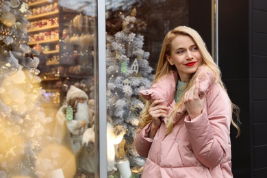 Young woman near store decorated for Christmas Photo of Young woman near store decorated for Christmas