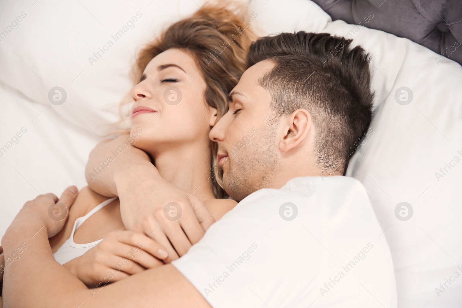 Lovely young couple sleeping in bed at home Photo of Lovely young couple sleeping in bed at home