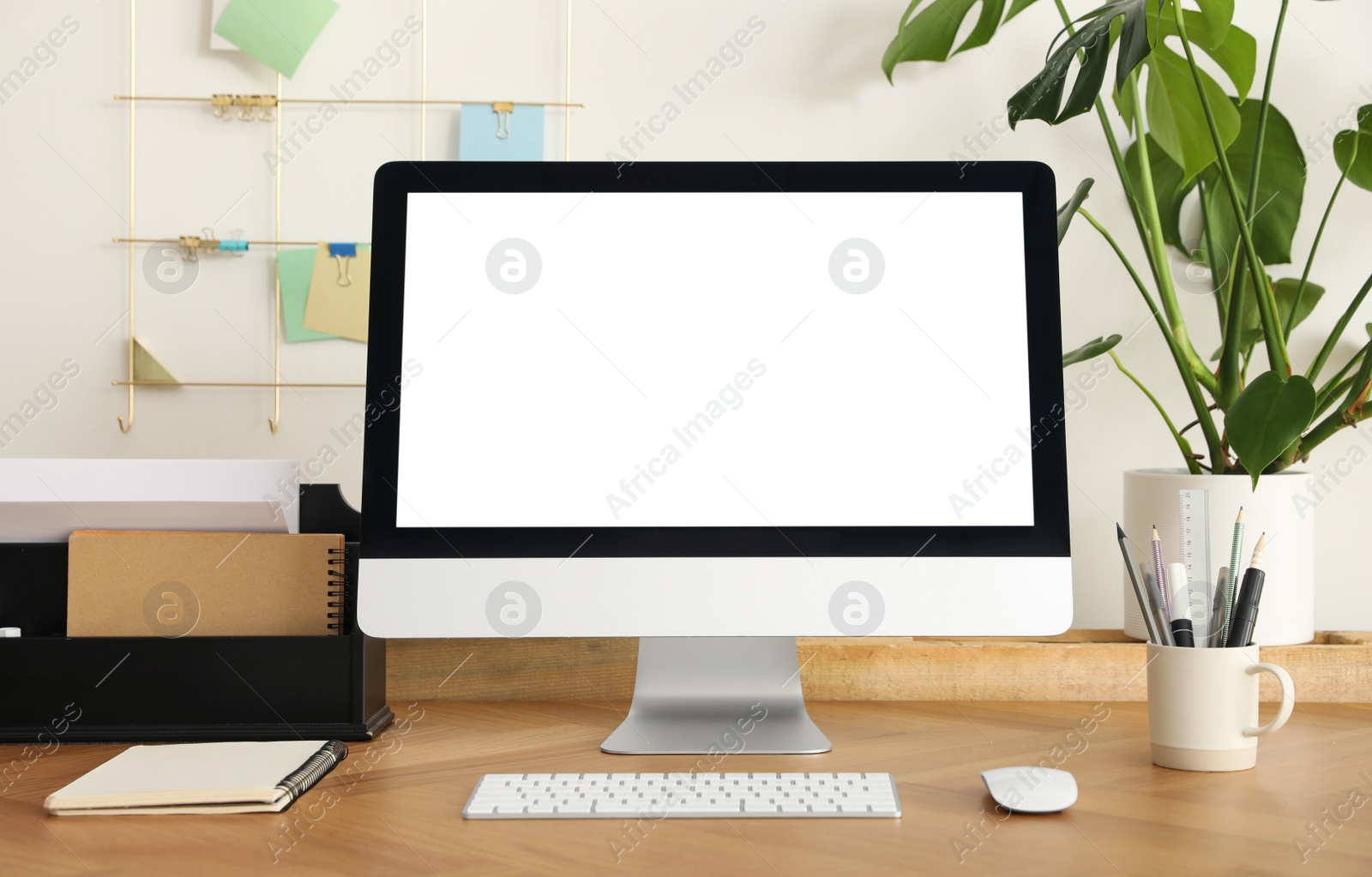 Comfortable workplace with modern computer near on table near white wall. Space for design Photo of Comfortable workplace with modern computer near on table near white wall. Space for design