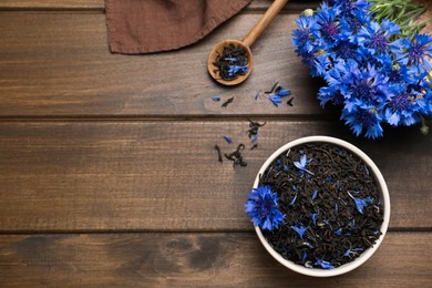 Composition with dry tea leaves and cornflowers on wooden table, flat lay. Space for text Photo of Composition with dry tea leaves and cornflowers on wooden table, flat lay. Space for text