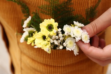 Woman wearing dress with flowers in pocket, closeup Photo of Woman wearing dress with flowers in pocket, closeup