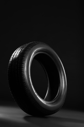 New car tire on black background Photo of New car tire on black background