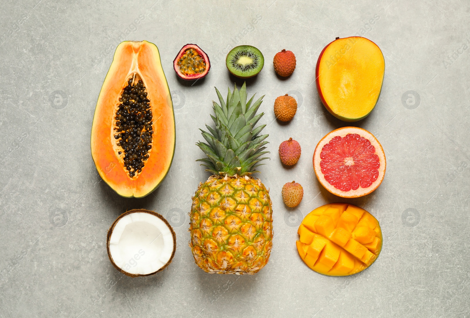 Fresh ripe papaya and other fruits on light grey table, flat lay Photo of Fresh ripe papaya and other fruits on light grey table, flat lay