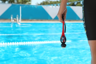 Swimmer with goggles near outdoor pool, closeup. Space for text Photo of Swimmer with goggles near outdoor pool, closeup. Space for text