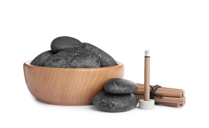 Incense stick smoldering near spa stones on white background Photo of Incense stick smoldering near spa stones on white background