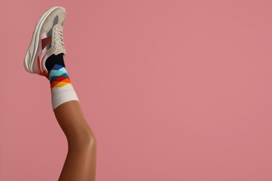 Woman wearing sneakers on pink background, closeup. Space for text Photo of Woman wearing sneakers on pink background, closeup. Space for text