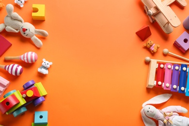 Flat lay composition with different toys on orange background. Space for text Photo of Flat lay composition with different toys on orange background. Space for text