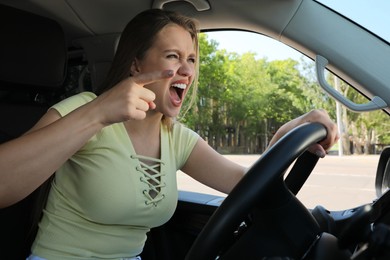 Emotional woman in car. Aggressive driving behavior Photo of Emotional woman in car. Aggressive driving behavior