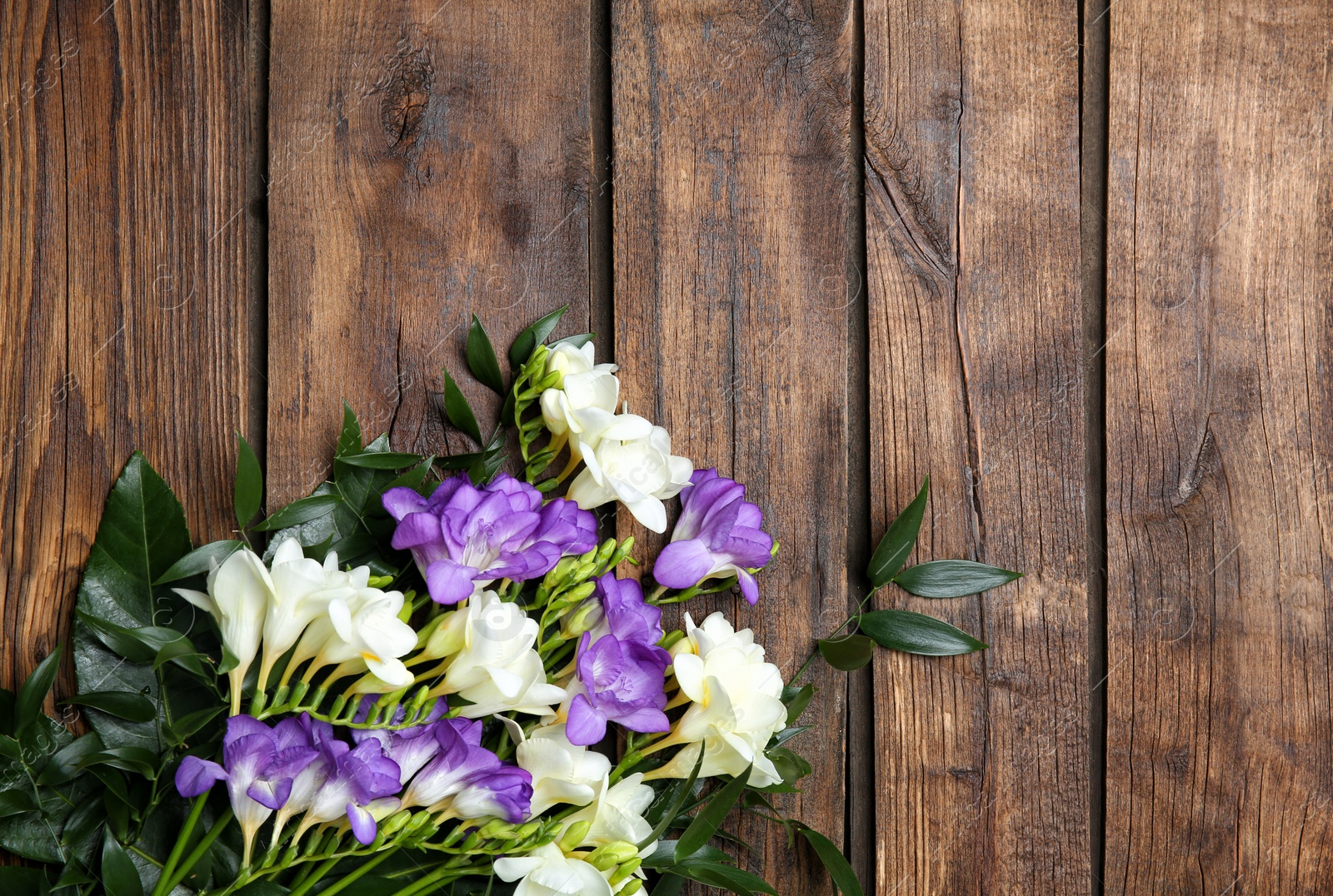 Beautiful freesia bouquet on wooden background Photo of Beautiful freesia bouquet on wooden background