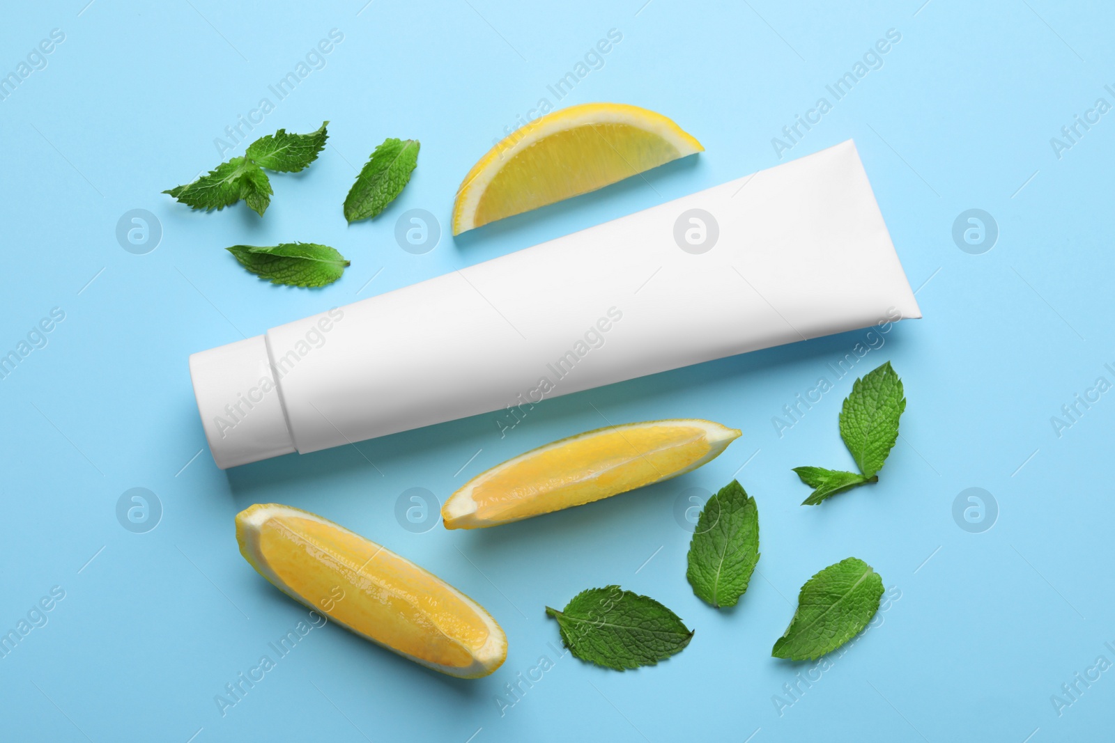 Blank tube of toothpaste with mint leaves and lemon slices on turquoise background, flat lay Photo of Blank tube of toothpaste with mint leaves and lemon slices on turquoise background, flat lay