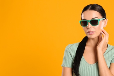Beautiful woman wearing sunglasses on yellow background. Space for text Photo of Beautiful woman wearing sunglasses on yellow background. Space for text