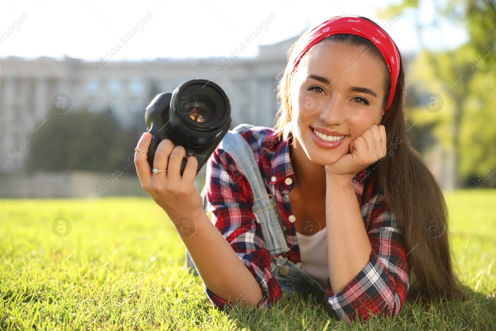 Young photographer with professional camera on green grass Photo of Young photographer with professional camera on green grass