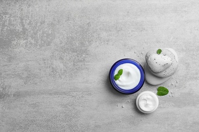Composition with body cream in jars on grey background Photo of Composition with body cream in jars on grey background