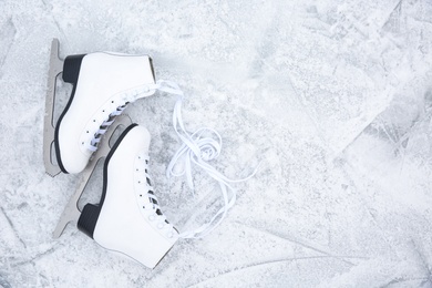 Pair of figure skates on ice, flat lay with space for text. Winter outdoors activities Photo of Pair of figure skates on ice, flat lay with space for text. Winter outdoors activities