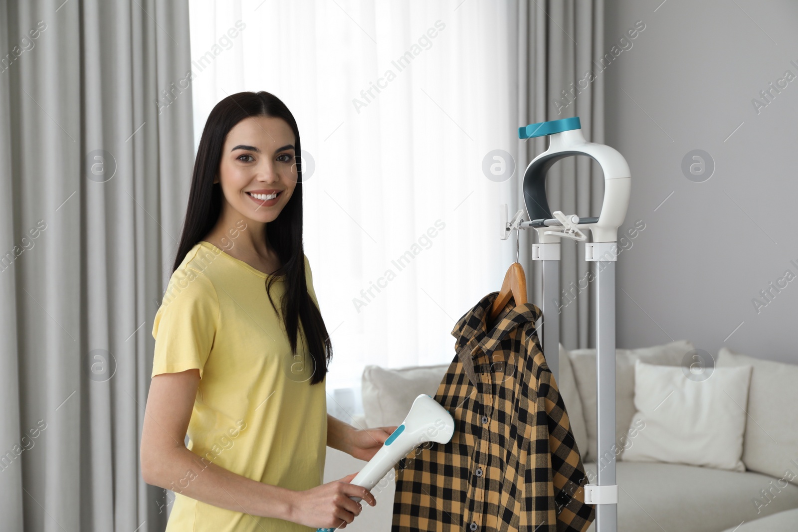 Woman steaming shirt on hanger at home Photo of Woman steaming shirt on hanger at home