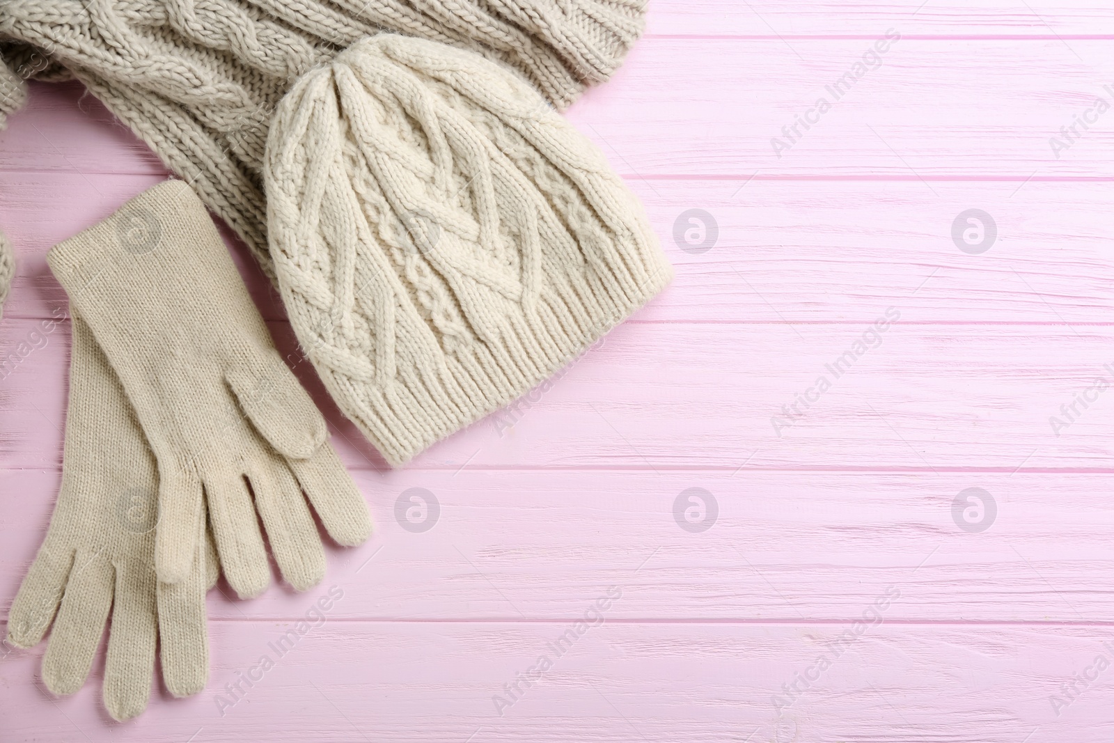 Stylish gloves, hat and scarf on pink wooden background, flat lay. Space for text Photo of Stylish gloves, hat and scarf on pink wooden background, flat lay. Space for text