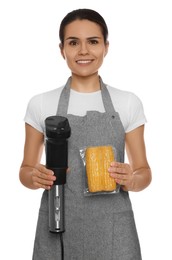 Beautiful young woman holding sous vide cooker and corn in vacuum pack on white background Photo of Beautiful young woman holding sous vide cooker and corn in vacuum pack on white background