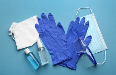 Flat lay composition with medical gloves, masks and hand sanitizers on blue background Photo of Flat lay composition with medical gloves, masks and hand sanitizers on blue background