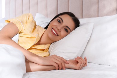 Woman lying in comfortable bed with white linens Photo of Woman lying in comfortable bed with white linens