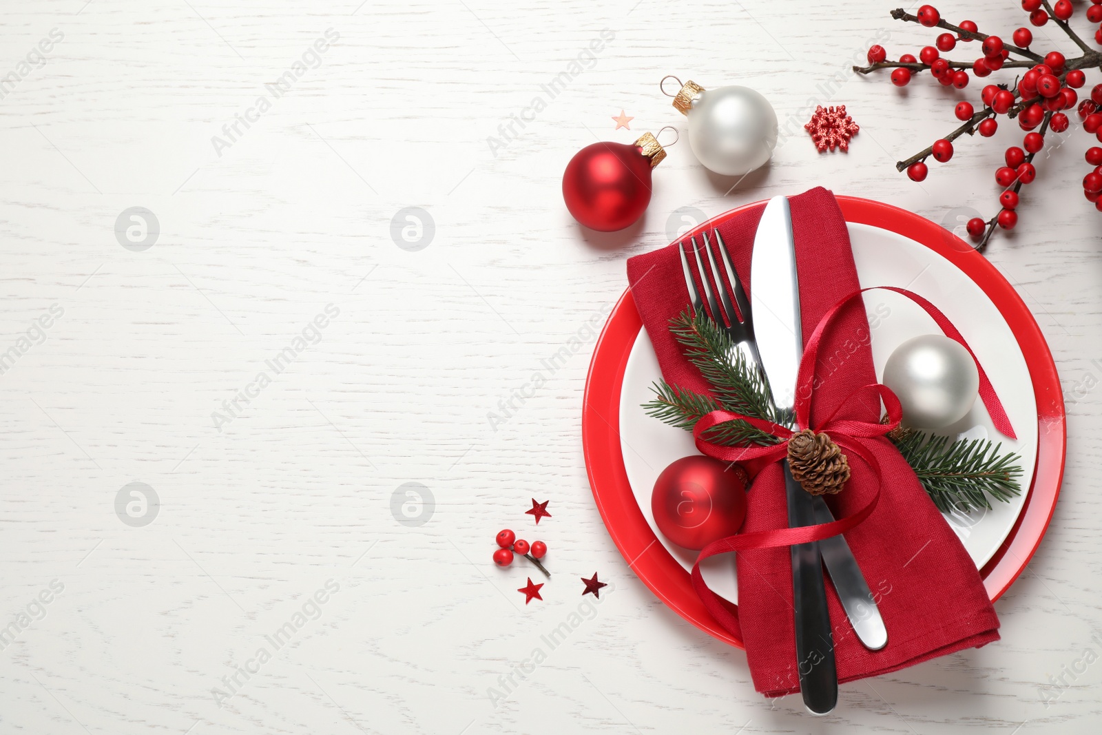 Festive table setting with beautiful dishware and Christmas decor on white wooden background, flat lay. Space for text Photo of Festive table setting with beautiful dishware and Christmas decor on white wooden background, flat lay. Space for text
