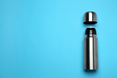 Stainless steel thermos on light blue background, top view. Space for text Photo of Stainless steel thermos on light blue background, top view. Space for text