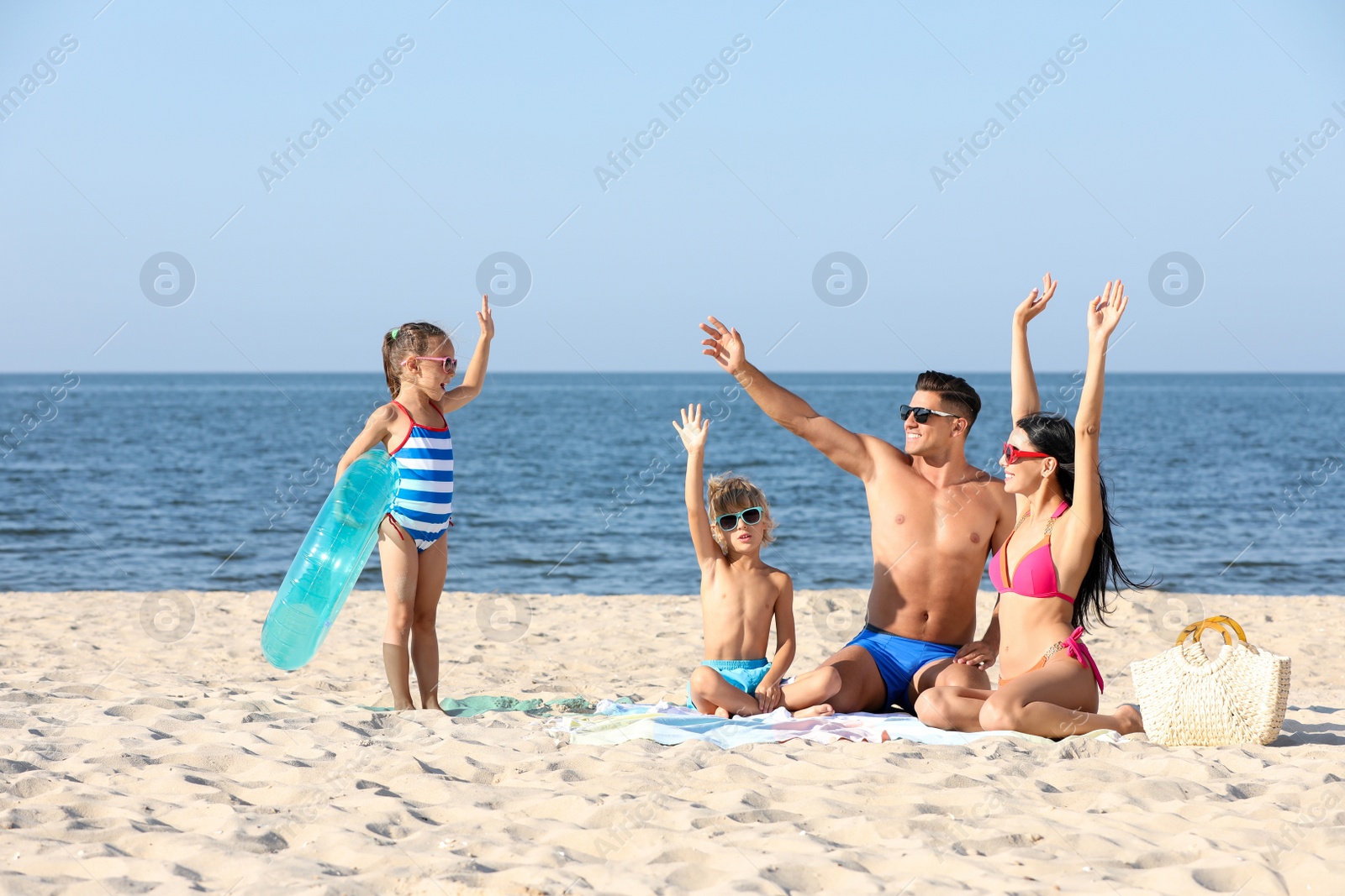 Photo of Happy family on sandy beach near sea. Summer holidays