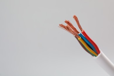 Cable with stripped wires on light background, closeup. Space for text Photo of Cable with stripped wires on light background, closeup. Space for text