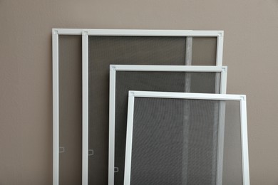 Set of window screens near beige wall Photo of Set of window screens near beige wall