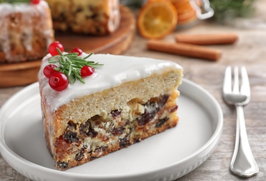 Slice of traditional Christmas cake decorated with rosemary and cranberries on table, closeup Photo of Slice of traditional Christmas cake decorated with rosemary and cranberries on table, closeup